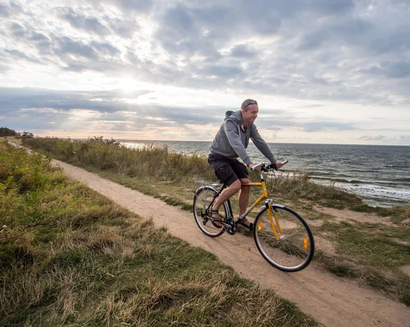 A man riding a bike along Baltic sea coast. Iron Curtain Trail.