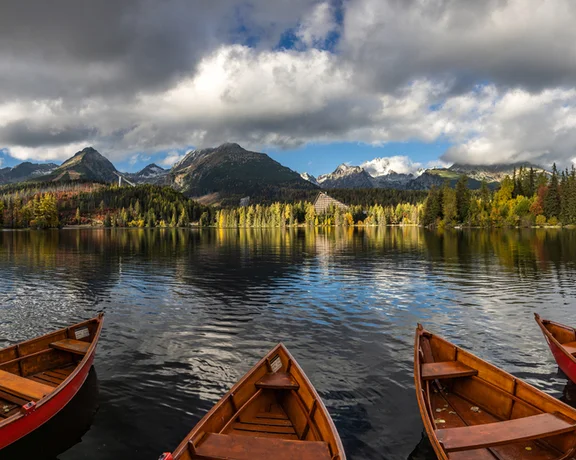 Float away on a romantic boat trip on crystal clear Štrbské pleso pond under the midday sun.