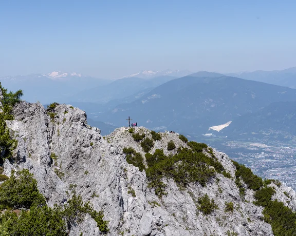 A peak summit of a mountain with a blue sky on the top.