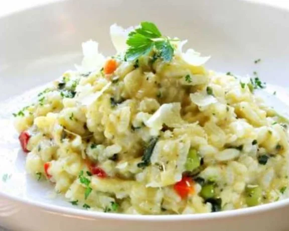 Savor a delectable, creamy risotto with vibrant veggies like zucchini, bell peppers, peas, and carrots.