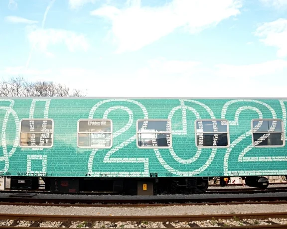 A green train carriage with turquoise "GO2025" graffiti, representing Nova Gorica and Gorizia's European Capital of Culture bid.