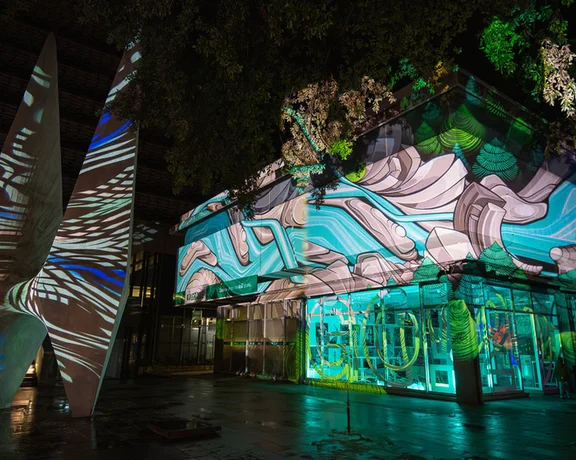 Modern building with abstract projection mapping at night.