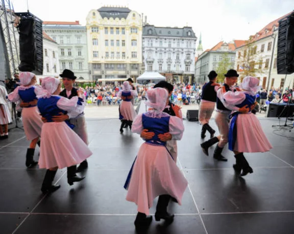 Traditional dancers perform on stage in costume with audience in background during the ÚĽUV Master Craftsmen Days.