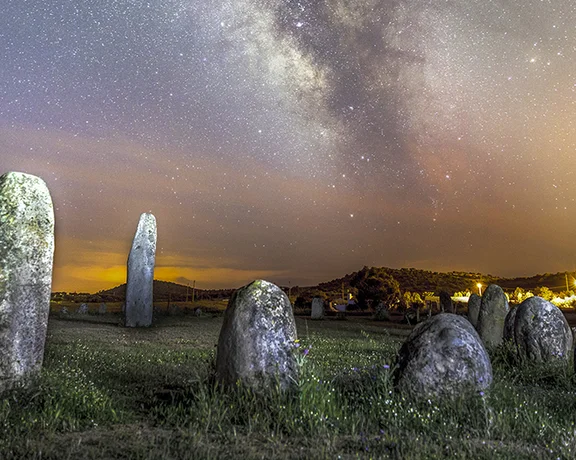 Megalithic stone circle under a starry sky in Alqueva, Portugal.