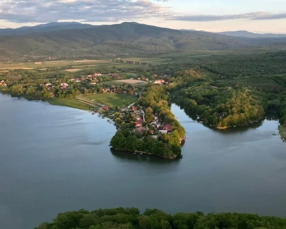 Aerial view of Surduc Lake with peninsulas and nearby village.
