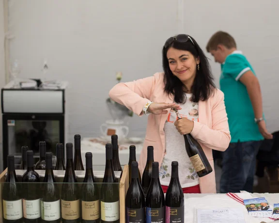 Woman presenting bottles of Slovak wine at a Strekov wine festival.