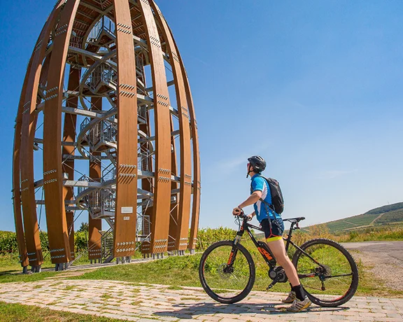 Cyclist visiting the modern wooden wine lookout tower in the Little Carpathians, Slovakia.