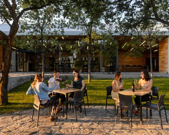 Friends enjoying wine tasting outdoors at Starý Vrch winery in Hustopeče, South Moravia.