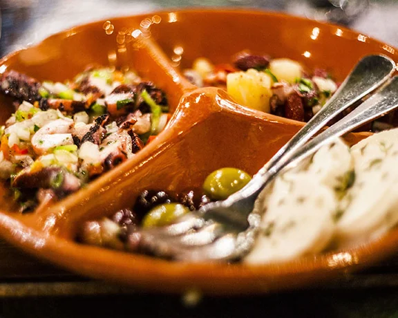 Portuguese Polvo de Escabeche marinated octopus salad with onions and olives.