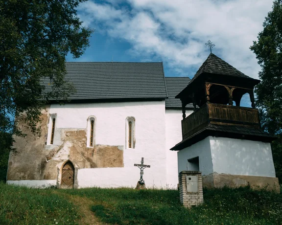 Exterior of the Gothic church in Rákoš, Slovakia, showcasing its historic architecture and white walls