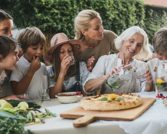 Family sharing a plate of traditional Slovenian food, representing sustainability and culinary tradition.