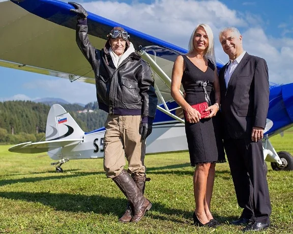 Pilot and visitors beside a vintage aircraft during the Flight to the Tannery of Europe experience in Šoštanj, Slovenia.