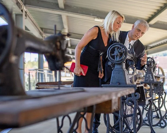 Visitors examining vintage sewing machines at the Museum of Leather Industry in Šoštanj, Slovenia.