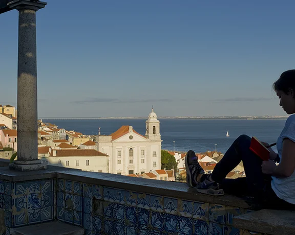 リスボンのサンタ・ルジア展望台：ブーゲンビリアや歴史的なアズレージョに囲まれた、アルファマの赤い屋根とタホ川を見渡すタイル張りのテラス