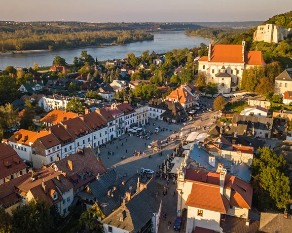 Aerial view of a historic riverside town with a central market square at sunset