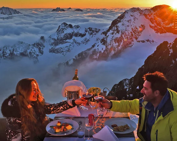 Couple dining at sunset on Lomnický štít in the High Tatras, Slovakia.