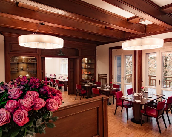 Elegant Michelin-level restaurant interior in Zlín with warm wood and roses.