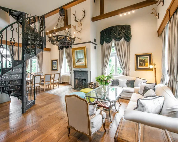 Luxurious chateau suite with spiral staircase and elegant furnishings.