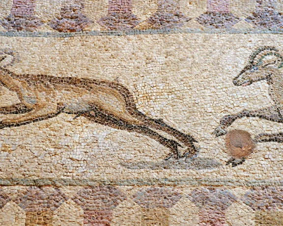 Ancient mosaic depicting two running goats with curved horns.