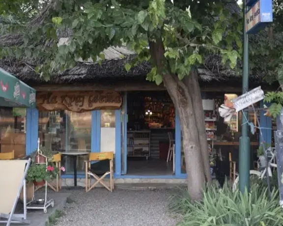 Cozy outdoor café with chairs, a tree, and a playful mannequin by the entrance.