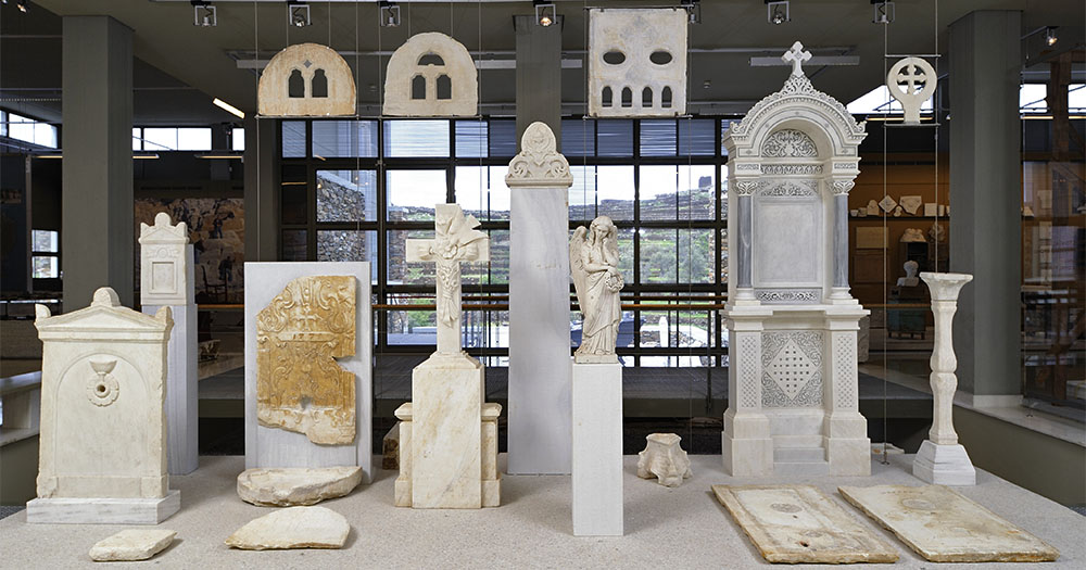 A display of various ornate marble artifacts, including tombstones, sculptures, and decorative panels in a museum setting.