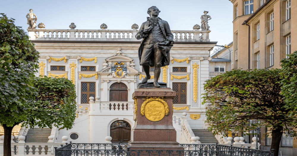 Statue of Johann Wolfgang von Goethe standing in front of the Old Stock Exchange building in Leipzig, Germany.