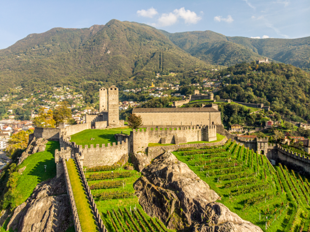 Castelgrande fortress nestled in the Swiss Alps, surrounded by lush green hills and scenic mountain landscape.