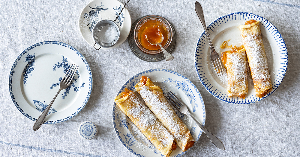 Austrian Marillen Palatschinken, sweet apricot pancakes dusted with powdered sugar, served as a traditional dessert.