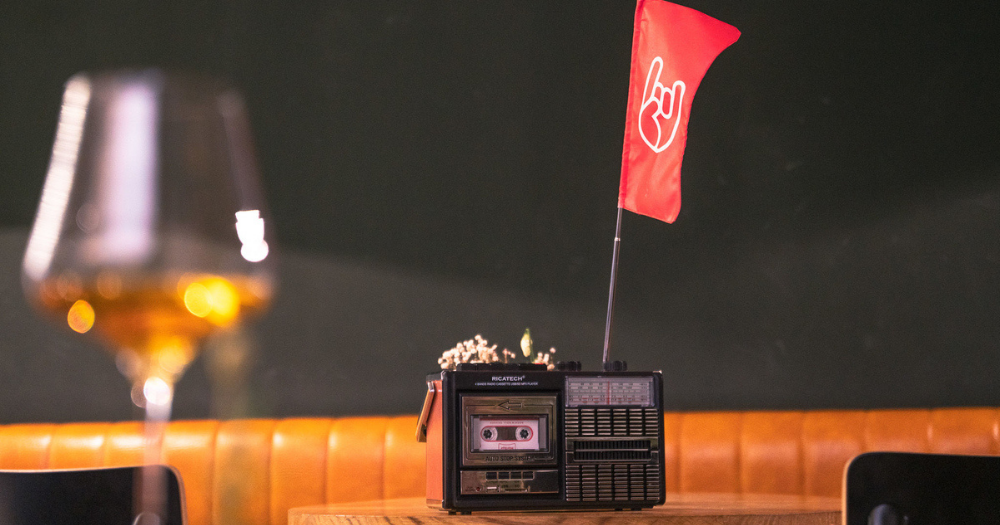 Glass of orange wine beside a vintage cassette player with a red flag in Slovenia.