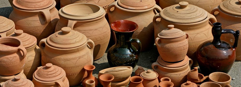 A collection of handcrafted clay pots and jugs of various sizes, showcasing intricate designs and earthy tones.