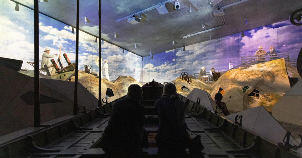 Immersive exhibit at TIRPITZ Museum, Denmark, featuring visitors viewing a projected World War II-era bunker scene.